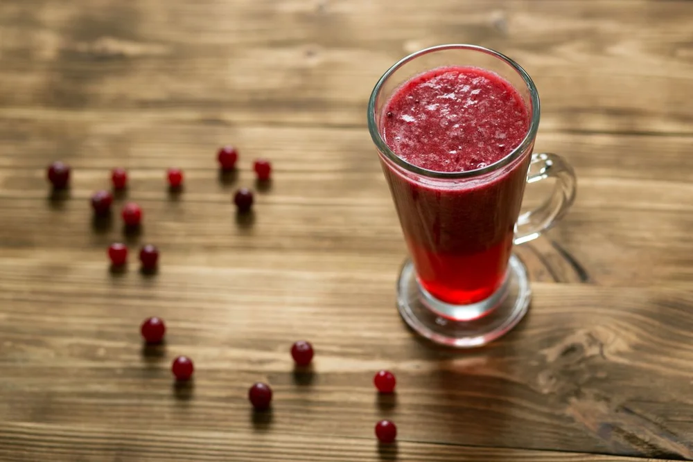 A red cranberry drink in a clear glass